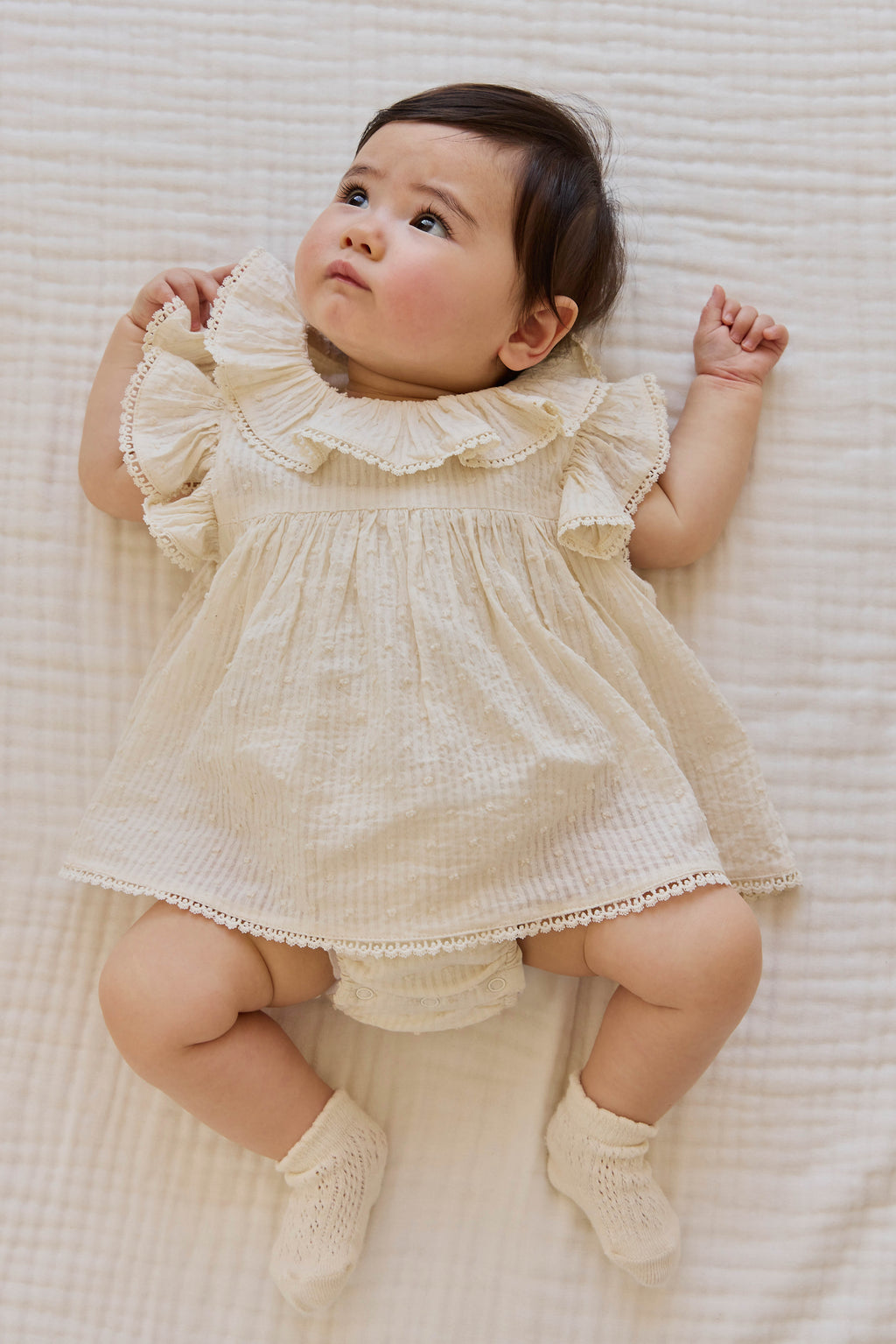 Combinaison bébé en mousseline de coton biologique unie parchemin romantique avec col volanté et manches flottantes 0-2 ans