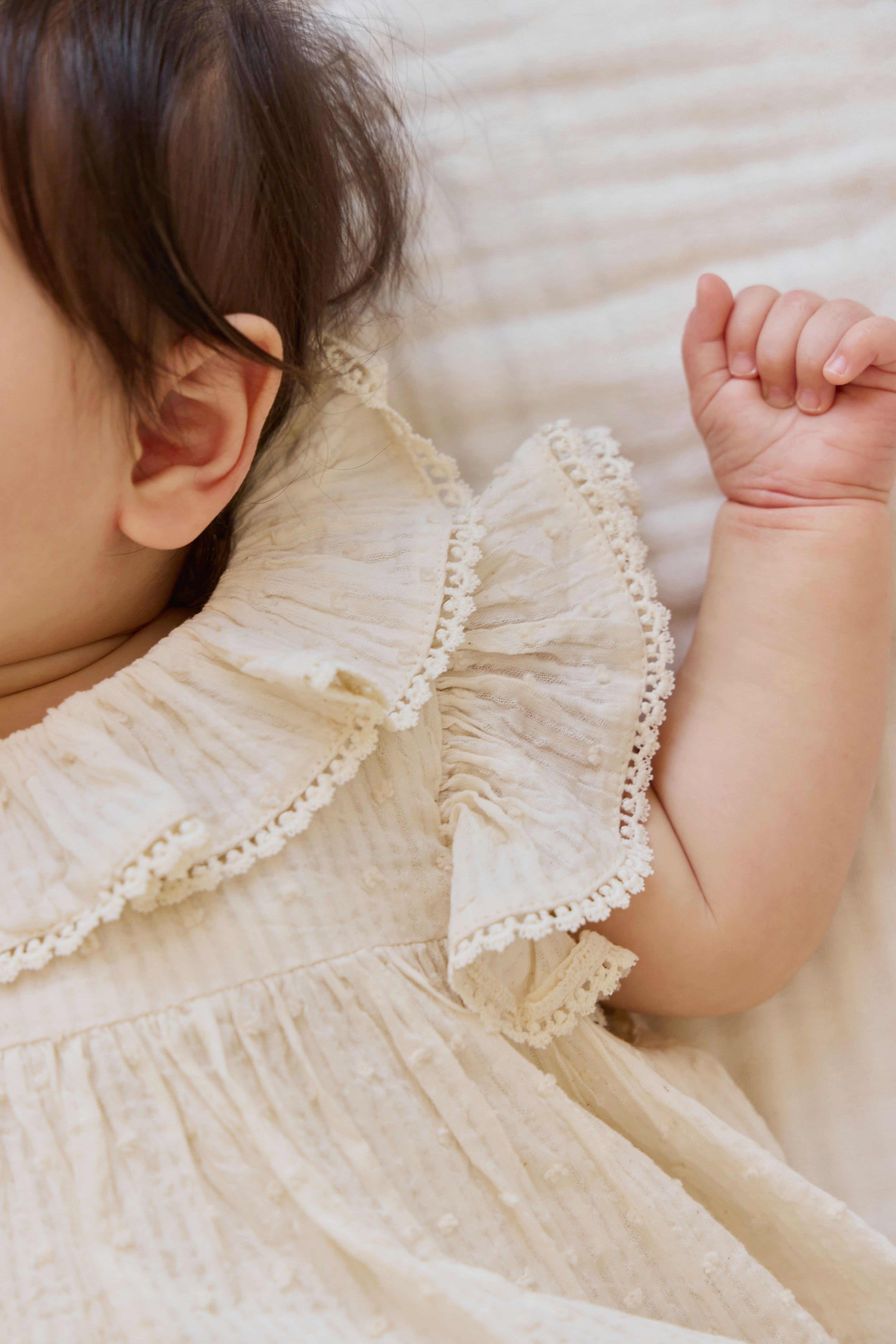 Combinaison bébé en mousseline de coton biologique unie parchemin romantique avec col volanté et manches flottantes 0-2 ans