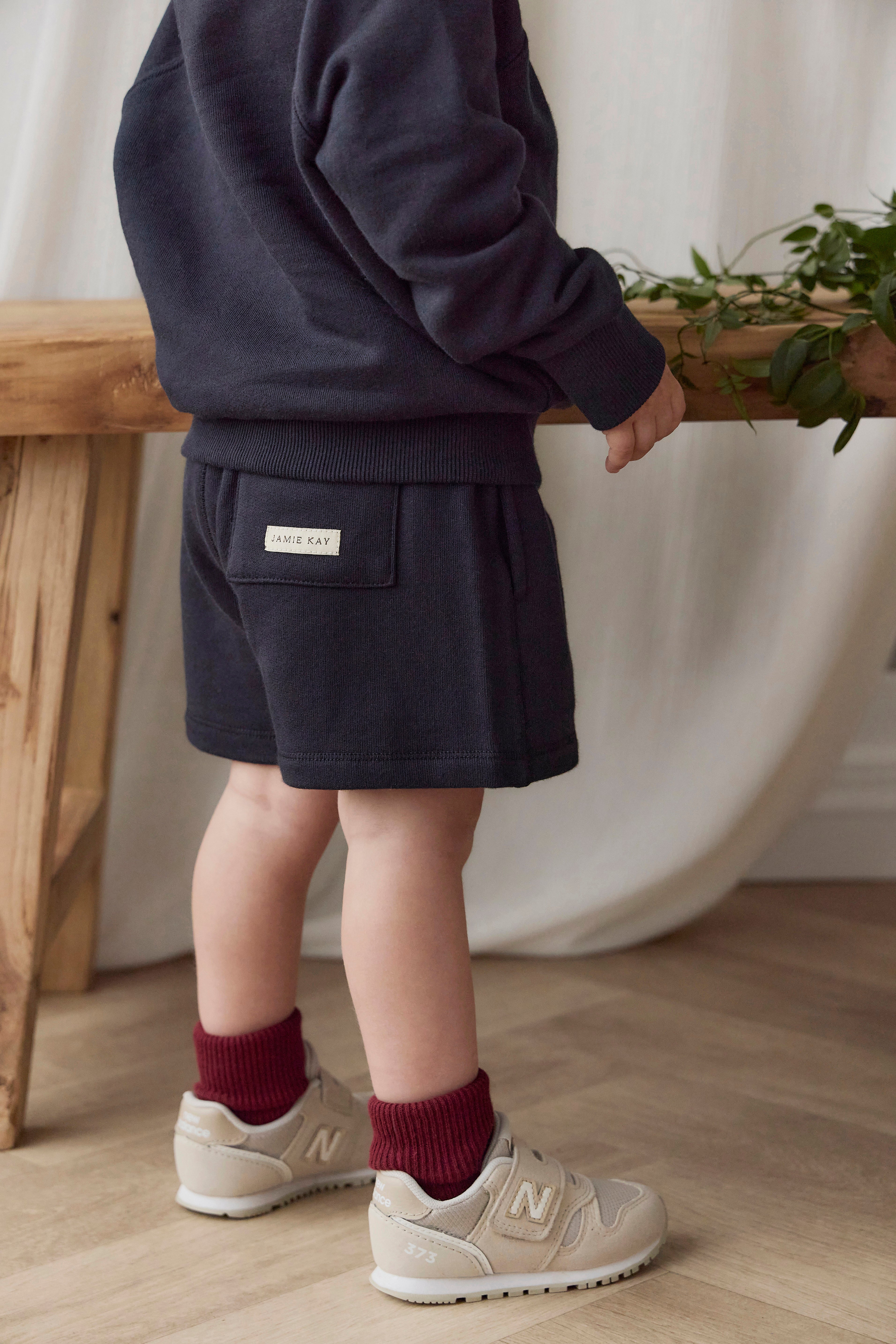 Short ample bleu marine en coton biologique avec taille élastiquée et cordon de serrage avec nœud pour enfants de 6 mois à 8 ans
